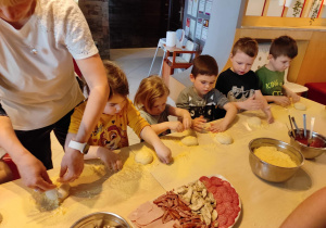 Dzieci w trakcie pracy nad własną pizzą